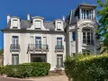 Belle demeure avec balcons en fer forgé, idéale pour une vente à réméré. Le soleil brille sur cette propriété.