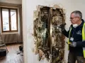 Expertise immobilière inspecte un mur dégradé par l'humidité, révélant des moisissures. Ce cas pourrait relever de la jurisprudence vice caché maison.