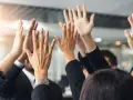 Des mains levées en signe de victoire, célébrant un succès collectif. L'équipe est unie, prête pour le quitus au syndic.