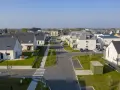 Vue aérienne d'un lotissement privé aux maisons modernes. La mairie a veillé aux obligations pour ce quartier résidentiel.