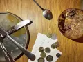 Sur une table en bois, un reçu et des pièces de monnaie sont posés près d'une assiette sale et d'un verre de dessert. Le patron peut-il garder les pourboires ?