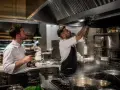 Installation d'une hotte d'extraction dans un restaurant en copropriété. Deux chefs travaillent sur le système de ventilation.