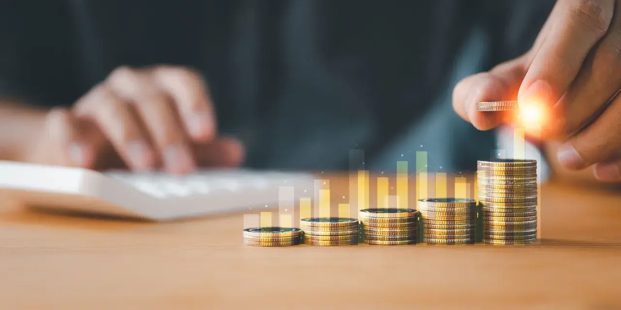 Main qui ajoute une pièce à une pile, symbolisant la croissance de la rémunération variable dans le respect du code du travail.