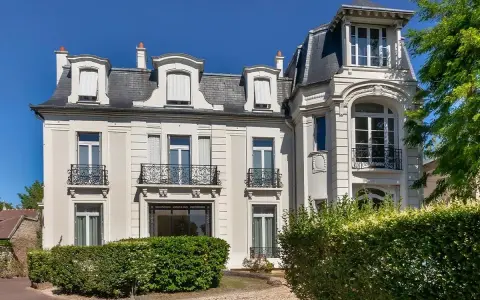 Belle demeure avec balcons en fer forgé, idéale pour une vente à réméré. Le soleil brille sur cette propriété.
