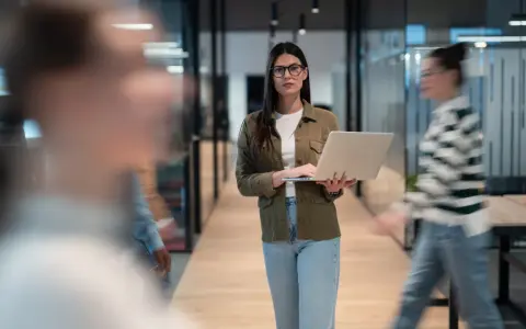Femme avec un ordinateur portable dans un bureau moderne, préparant une annonce légale changement de gérant.