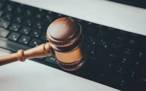 Marteau de juge sur un clavier d'ordinateur, symbolisant les revenus pris en compte pour pension alimentaire et la justice numérique.