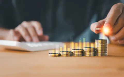 Main qui ajoute une pièce à une pile, symbolisant la croissance de la rémunération variable dans le respect du code du travail.