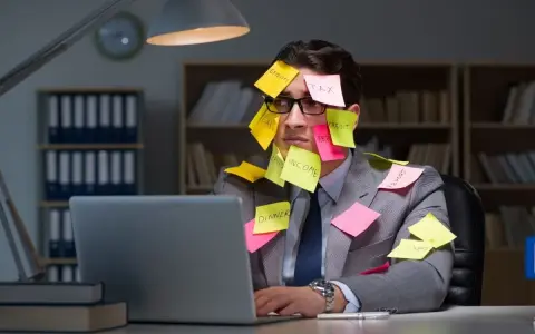 Homme submergé par des post-its, symptômes de burn out. Médecine du travail à considérer.