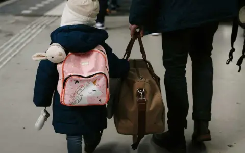 Enfant avec sac à dos licorne et doudou, accompagnant un adulte. Voyage pour une autorisation de sortie de territoire mineur parents séparés.
