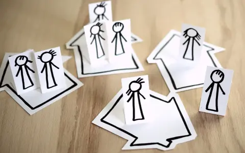 Petites maisons en papier avec des bonshommes dessinés, symbolisant une famille face à un délai de prévenance et une clause de mobilité.