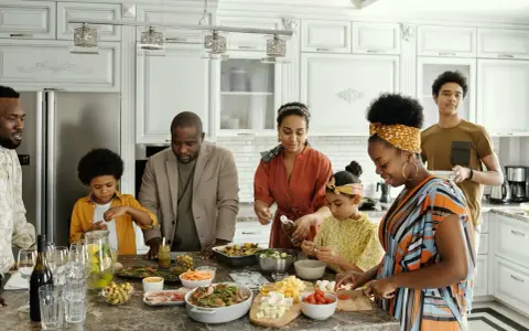 Une famille prépare un repas ensemble, partageant des moments précieux. Les ingrédients sont disposés sur le comptoir, comme un trésor **réduit aux acquets** de leur amour.