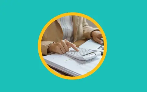 Une personne utilise une calculatrice sur des documents pour apprendre comment payer moins d'impôts.