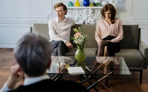 Un couple en discussion avec un avocat, cherchant une aide juridictionnelle pour leur divorce.