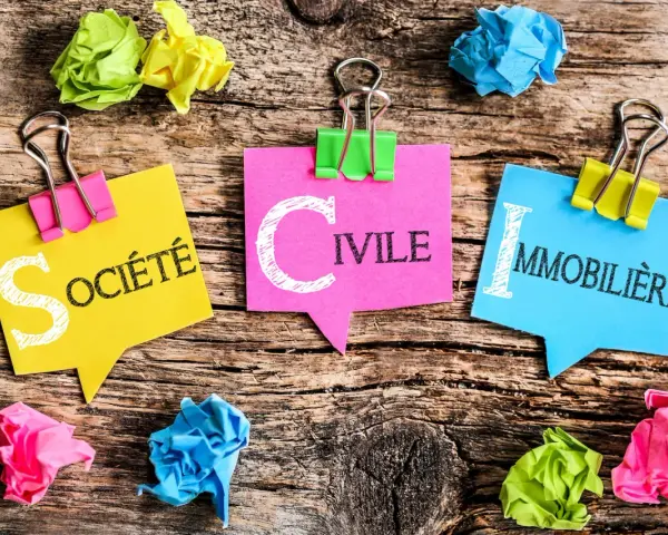 Trois post-its colorés forment le mot "SOCIÉTÉ CIVILE IMMOBILIÈRE". Idéal pour gérer un déficit foncier SCI.