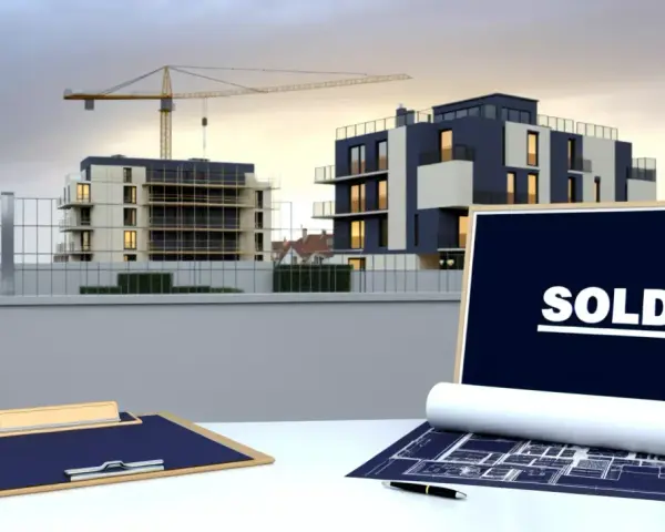 Chantier immobilier avec immeubles modernes, grue et panneau "SOLD". Pas de retard livraison VEFA, tout est vendu !