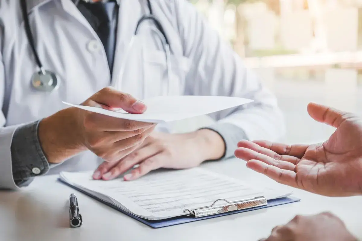Un médecin du travail tend un document, peut-être un refus d'inaptitude, à un patient.