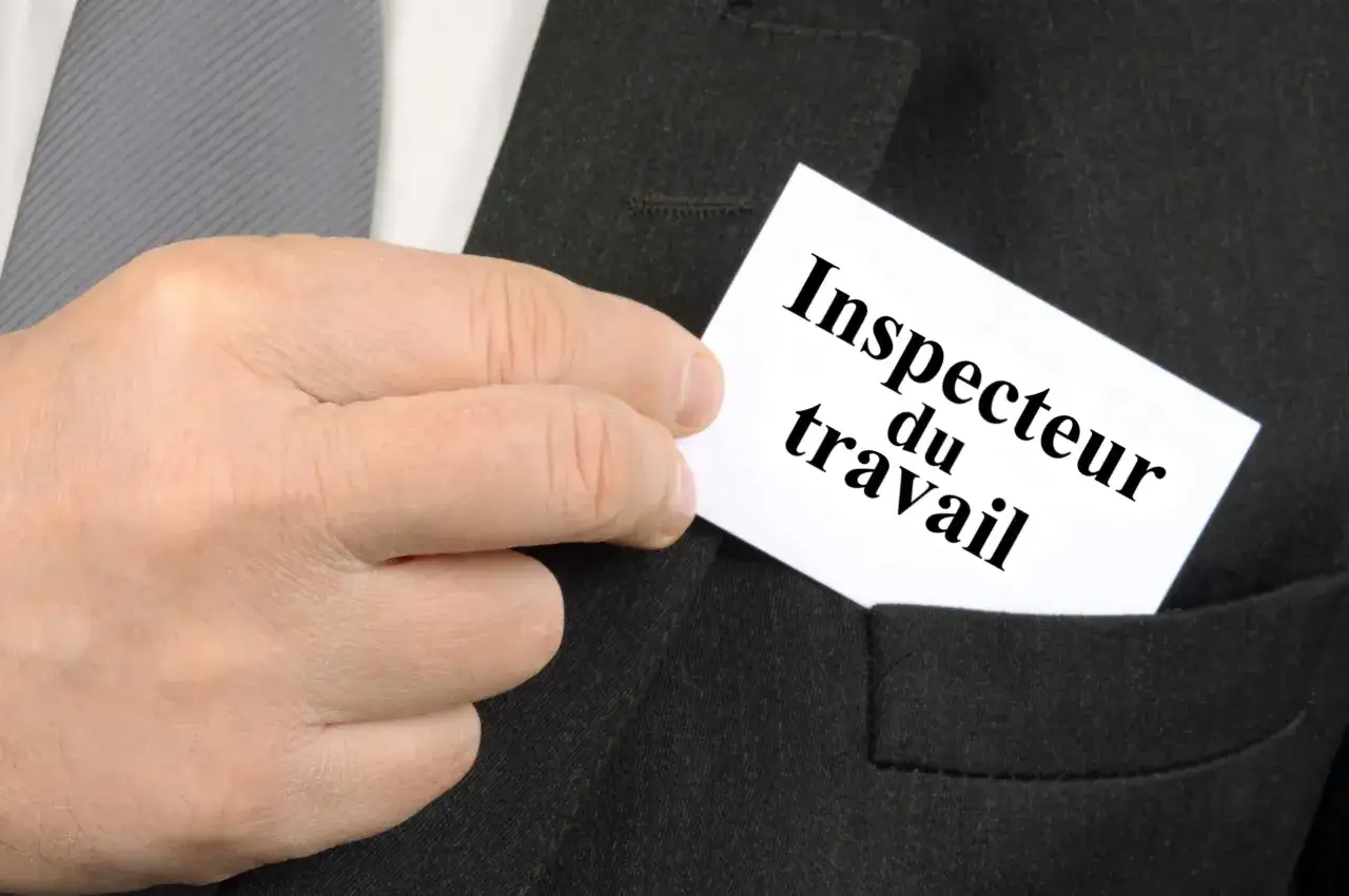 Une main sort une carte de visite d'une poche de costume. La carte indique 