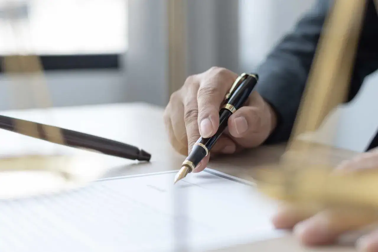Main tenant signe un document, peut-être pour le calcul d'indemnité d'éviction bail commercial résidence de tourisme.